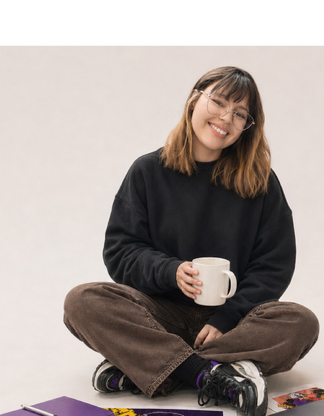 Renata, designer da Reh Illustra, sentada com ilustrações ao redor